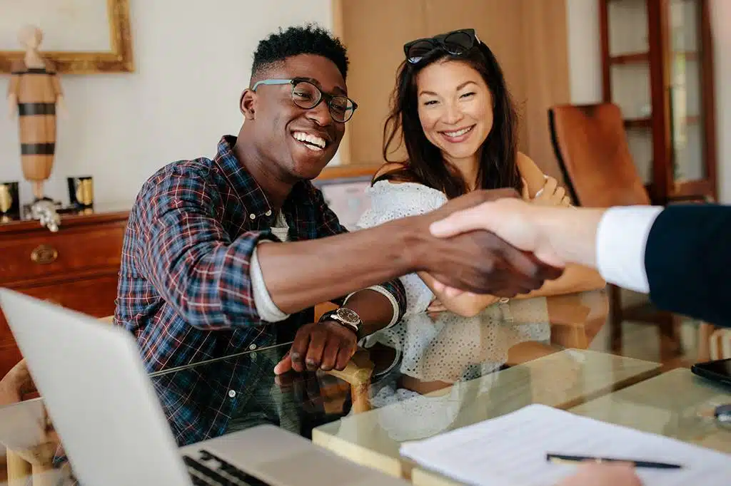 Couple signing for investment and shaking a hand